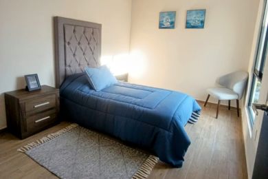 Cama individual silla estante buro base cobijas azules